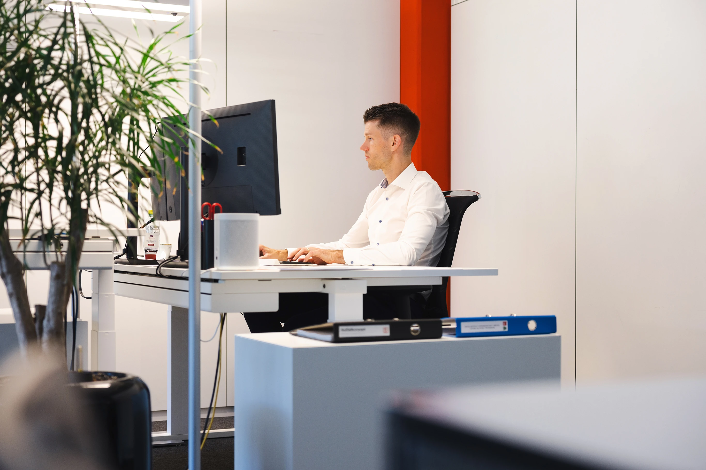 IMS-Mitarbeiter arbeitet konzentriert an einem Computer im Büro